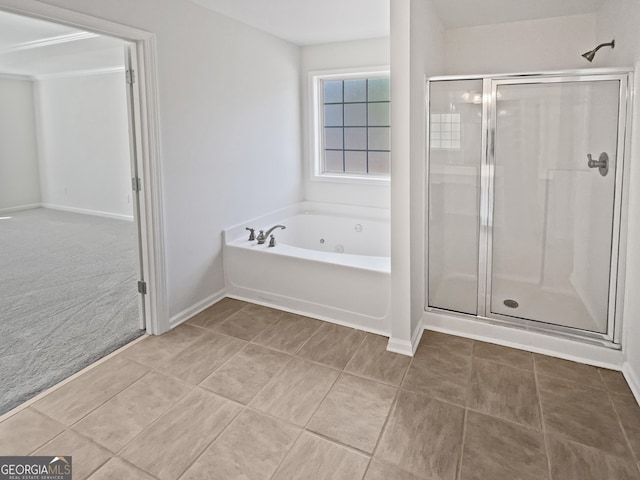 bathroom featuring a stall shower, a jetted tub, baseboards, and tile patterned floors