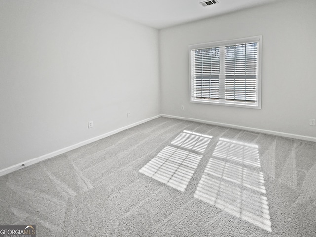 empty room featuring visible vents, baseboards, and carpet flooring