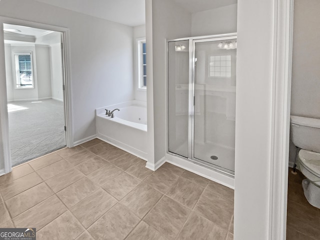 bathroom featuring toilet, a stall shower, baseboards, and a garden tub