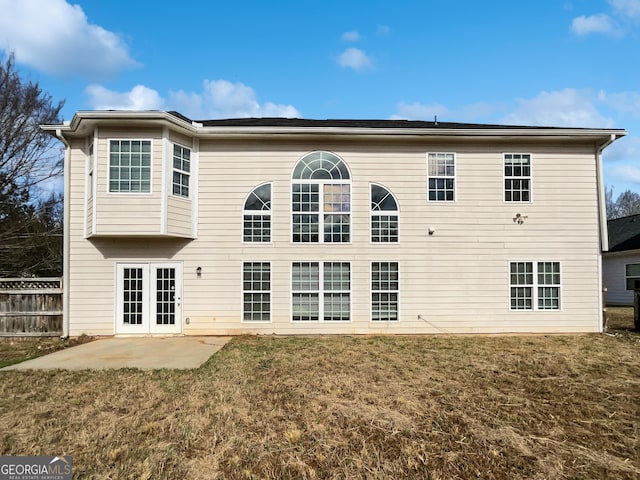 rear view of property with french doors, a patio area, a lawn, and fence