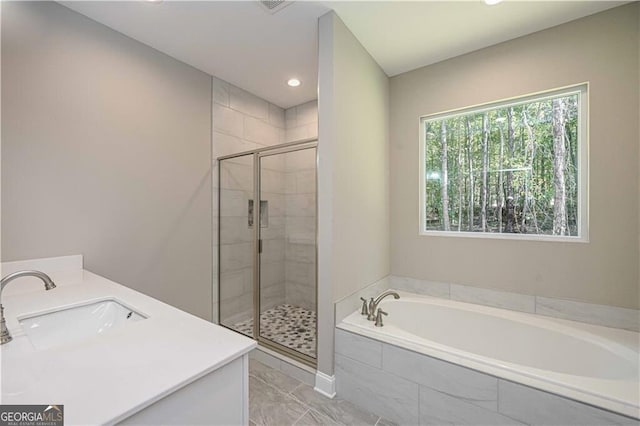 bathroom with a garden tub, a shower stall, marble finish floor, and a sink