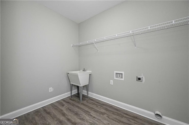 washroom featuring hookup for an electric dryer, laundry area, washer hookup, dark wood-style flooring, and baseboards