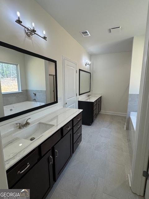 bathroom with two vanities, tile patterned floors, a garden tub, visible vents, and a sink