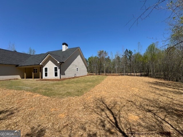 back of house with a patio area and a chimney