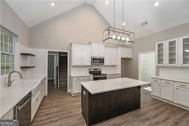 kitchen with appliances with stainless steel finishes, dark wood-type flooring, a sink, and open shelves