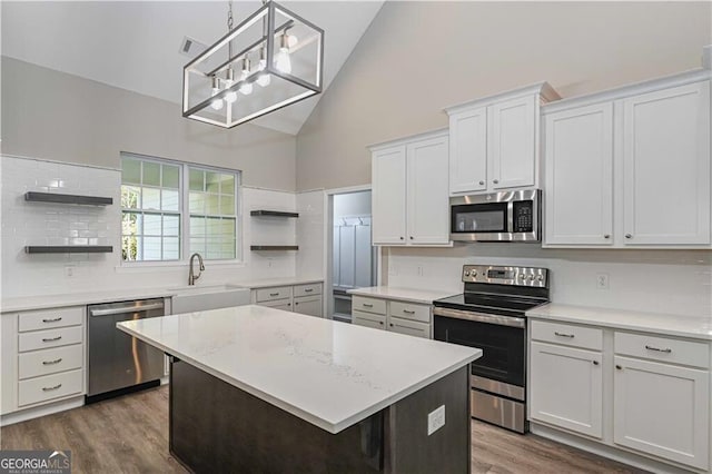 kitchen featuring white cabinets, appliances with stainless steel finishes, light countertops, open shelves, and a sink