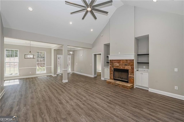 unfurnished living room with dark wood-type flooring, a fireplace, and baseboards