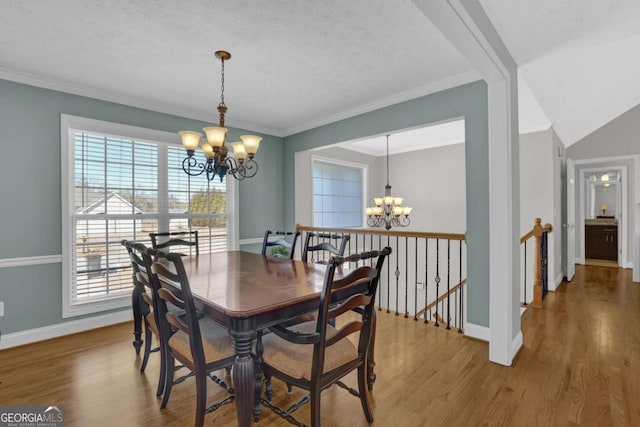 dining area featuring wood finished floors, baseboards, and an inviting chandelier