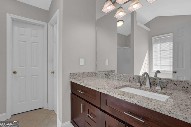 bathroom featuring tile patterned floors, vaulted ceiling, and vanity