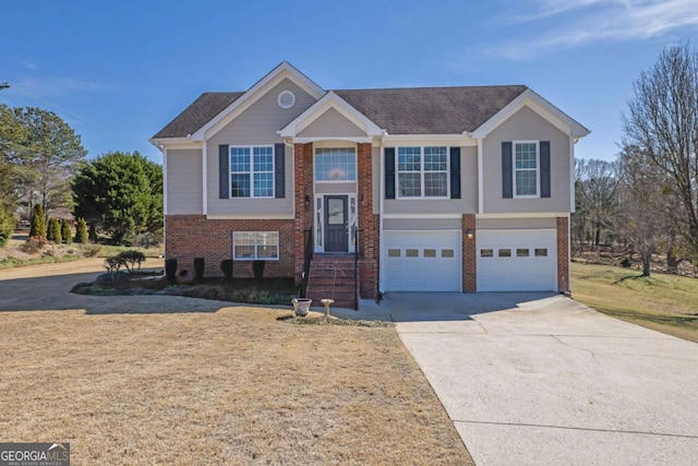 raised ranch featuring a garage, concrete driveway, and brick siding