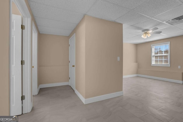 interior space featuring visible vents, baseboards, ceiling fan, and a drop ceiling