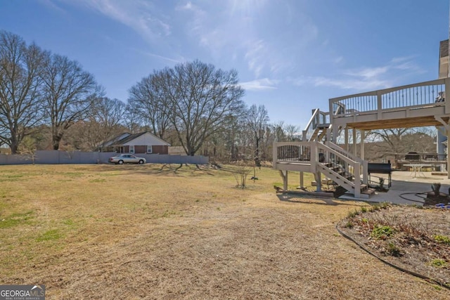 view of yard featuring stairs, a patio, a deck, and fence