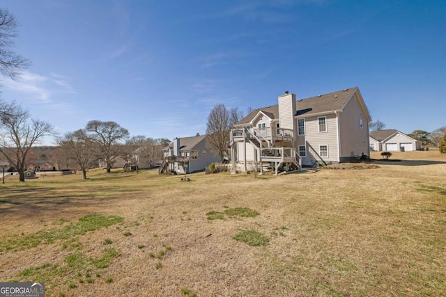 rear view of property featuring a chimney, a residential view, a deck, and a yard