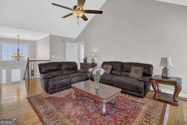 living area featuring high vaulted ceiling, ornamental molding, light wood-style flooring, and baseboards