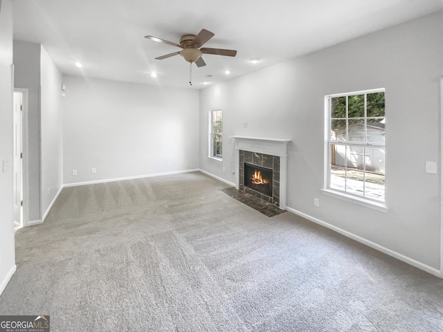 unfurnished living room featuring carpet, recessed lighting, baseboards, and a tile fireplace