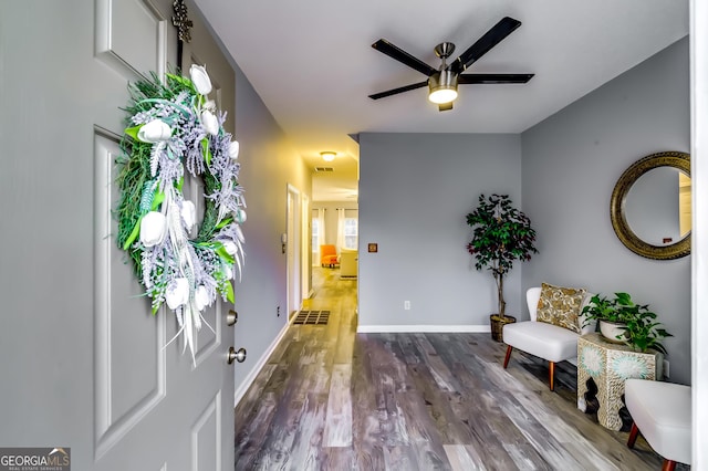 sitting room with visible vents, dark wood finished floors, a ceiling fan, and baseboards