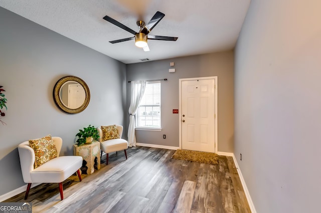 entrance foyer with a textured ceiling, wood finished floors, a ceiling fan, visible vents, and baseboards