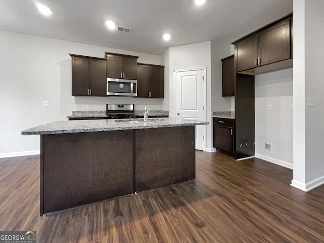 kitchen featuring stainless steel appliances, dark wood-type flooring, visible vents, and dark brown cabinetry