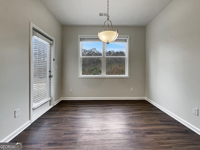 unfurnished dining area featuring dark wood-style flooring, visible vents, and baseboards