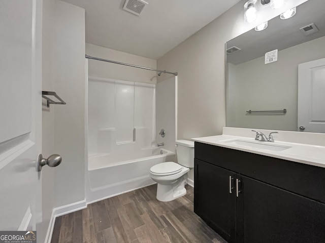 bathroom featuring shower / washtub combination, visible vents, toilet, vanity, and wood finished floors