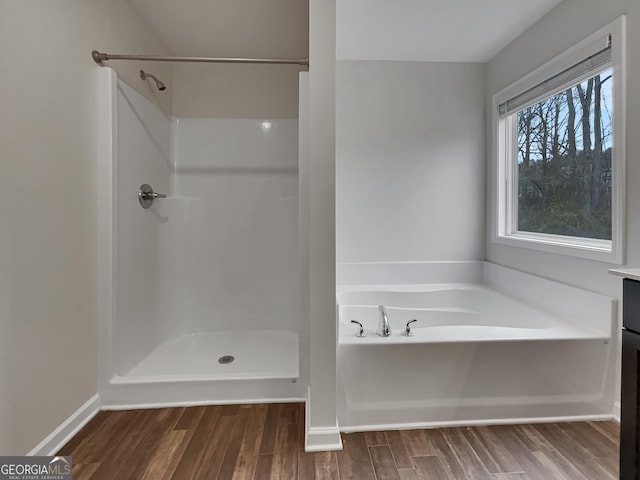 full bath featuring a shower, a garden tub, baseboards, and wood finished floors