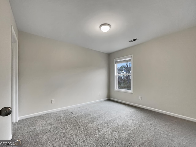 carpeted spare room featuring baseboards and visible vents