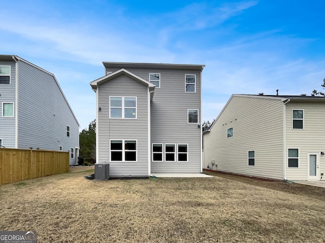 back of property with fence, a patio, a lawn, and central AC unit