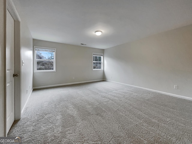 carpeted empty room with visible vents and baseboards