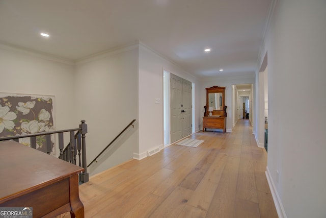 hallway with light wood-style floors, recessed lighting, an upstairs landing, and crown molding