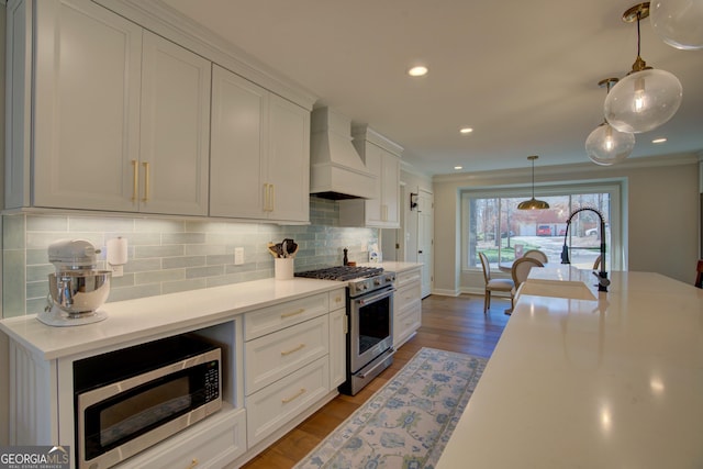 kitchen featuring premium range hood, white cabinetry, stainless steel appliances, and light countertops