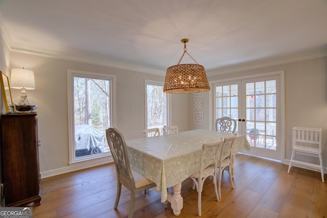 dining room featuring ornamental molding, a healthy amount of sunlight, and hardwood / wood-style flooring