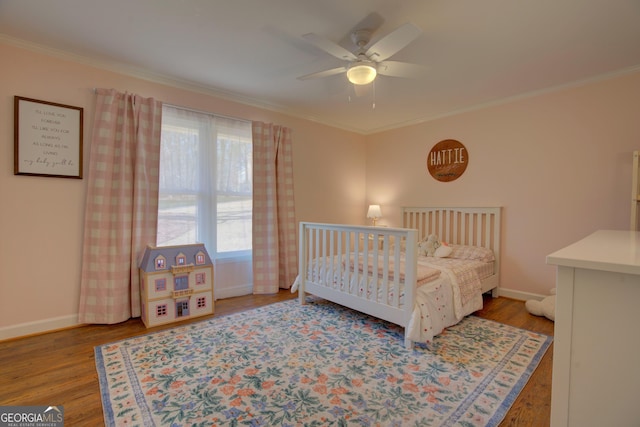 bedroom featuring ornamental molding, ceiling fan, baseboards, and wood finished floors