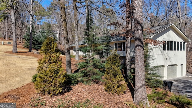 view of side of home featuring driveway and an attached garage