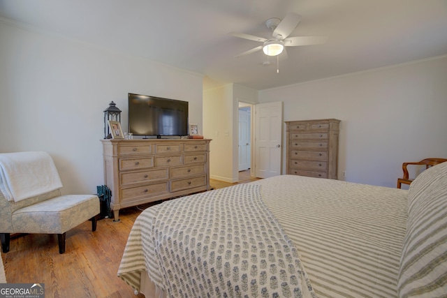 bedroom featuring crown molding, a ceiling fan, and light wood-style floors