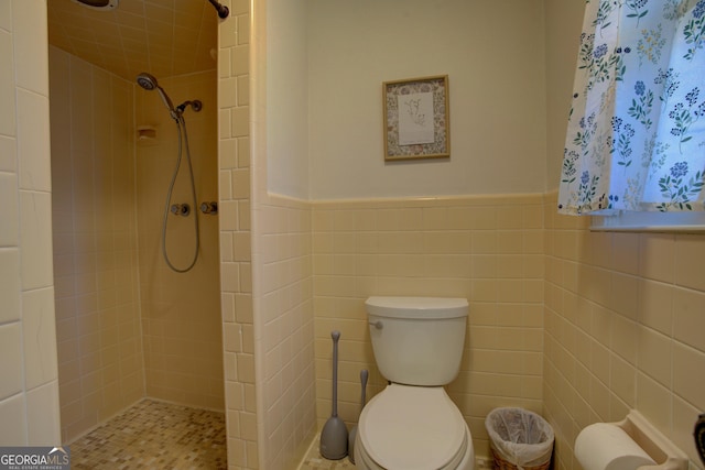 full bath featuring tiled shower and toilet