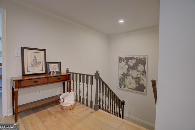 corridor with baseboards, wood finished floors, crown molding, an upstairs landing, and recessed lighting