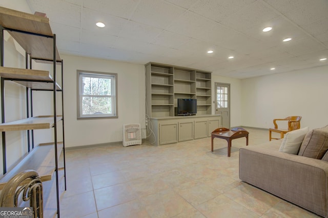 living area featuring a drop ceiling, recessed lighting, and baseboards