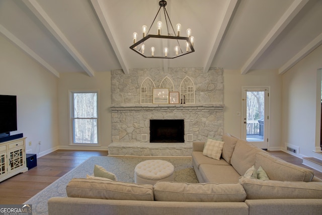 living room with vaulted ceiling with beams, a fireplace, visible vents, wood finished floors, and baseboards