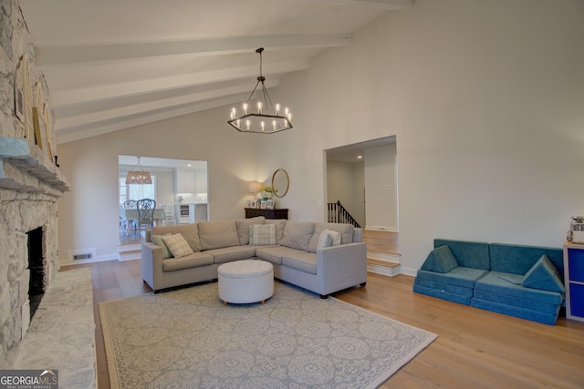 living area featuring a fireplace, a chandelier, beamed ceiling, and wood finished floors