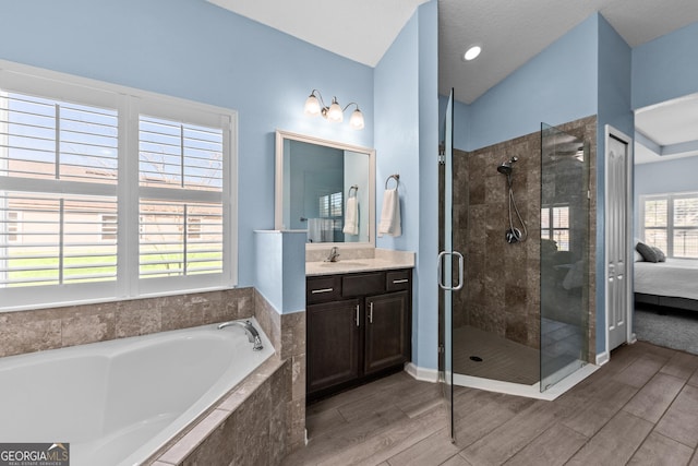 full bathroom with connected bathroom, a garden tub, vanity, a shower stall, and wood finish floors