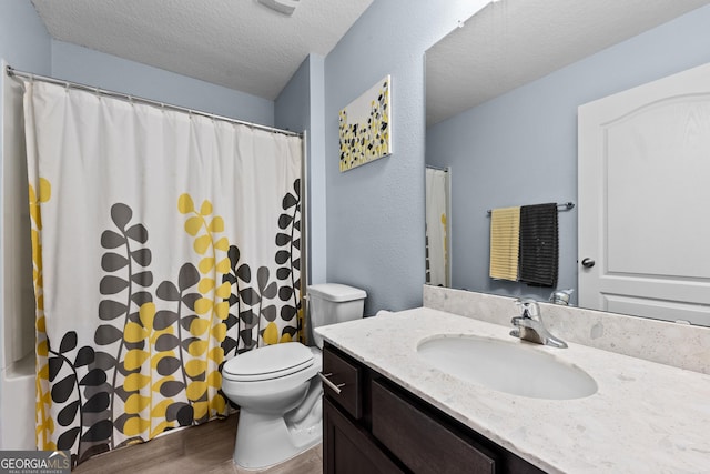 full bathroom with curtained shower, toilet, vanity, a textured ceiling, and wood finished floors