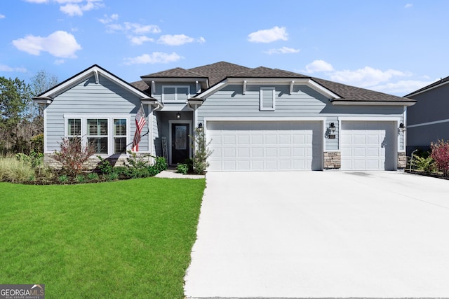 view of front of house with roof with shingles, concrete driveway, an attached garage, a front yard, and stone siding