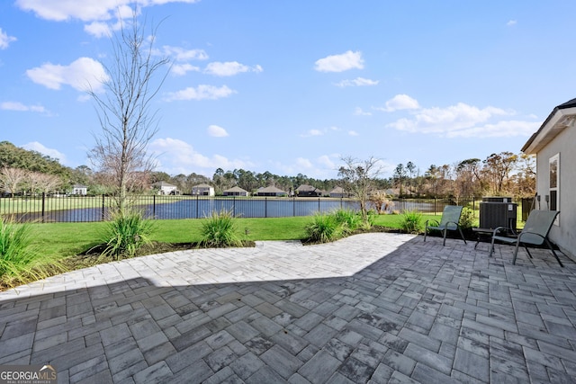 view of patio featuring a water view, a fenced backyard, and cooling unit