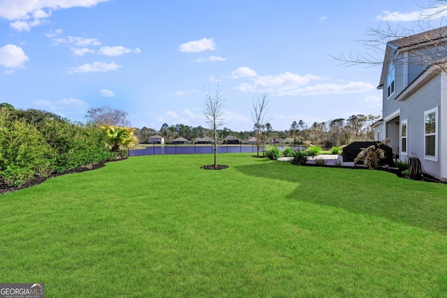 view of yard with a water view and fence