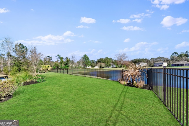 view of yard with a water view and fence