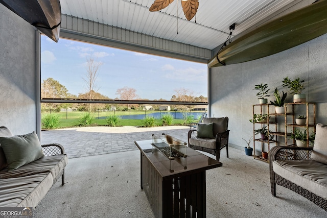 view of patio featuring an outdoor living space with a fire pit, a water view, and ceiling fan