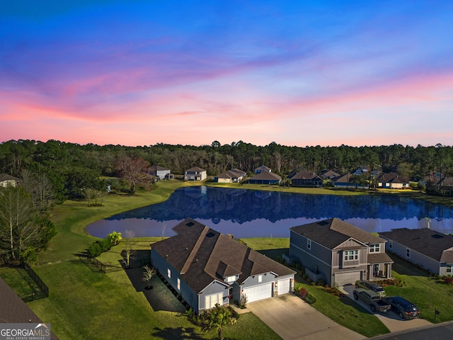 aerial view at dusk with a residential view and a water view