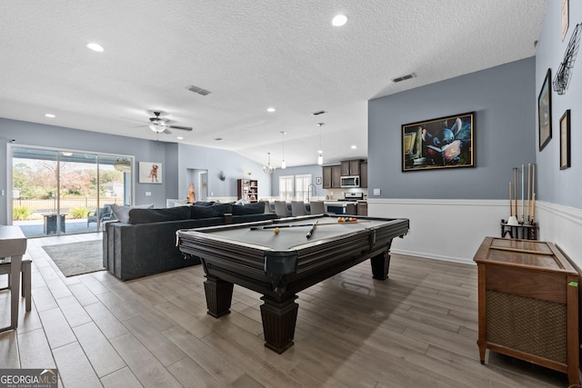 recreation room featuring lofted ceiling, plenty of natural light, visible vents, and wood finished floors