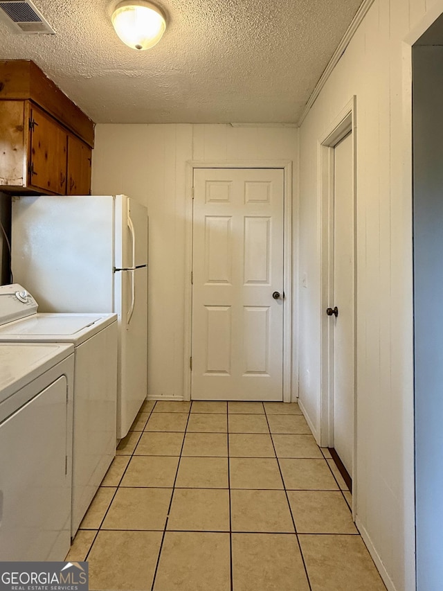 312 Schuman Dr, Bloomingdale, GA 31302 - kitchen with washing machine and clothes dryer, a textured ceiling, light tile patterned floors, and light countertops