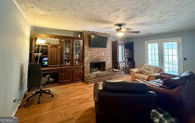 312 Schuman Dr, Bloomingdale, GA 31302 - living room with a desk, ceiling fan, light wood-style flooring, a brick fireplace, and french doors
